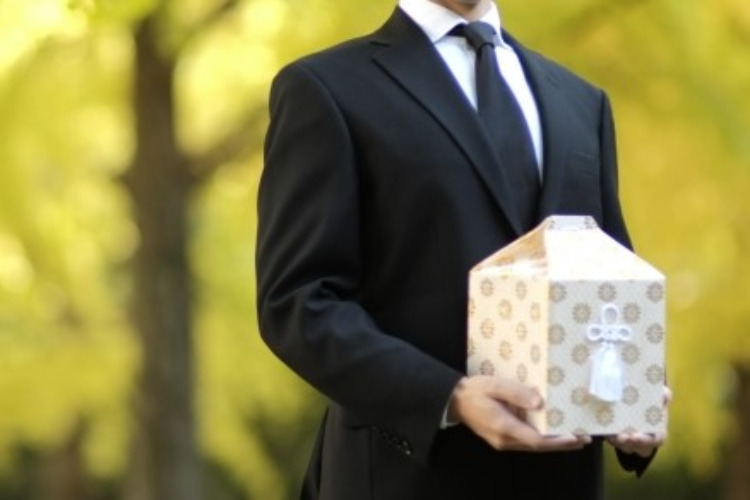 骨壷を持つ男性